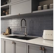 Küchenszene mit Spüle, Armatur, Fliesen und Küchenutensilien