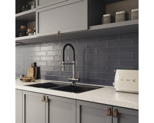 Küchenszene mit Spüle, Armatur, Fliesen und Küchenutensilien