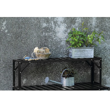 Gartenszene mit Pflanzenregal, Zinkgießkanne, Pflanzen und Gartenzubehör