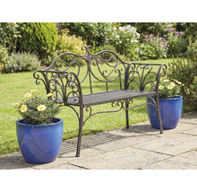 Verzierter Metalgartenbank mit Blumentöpfen auf einer Gartenterrasse