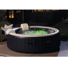 Aufblasbarer Whirlpool mit Kopfstützen und farbig beleuchtetem Wasser im Garten.