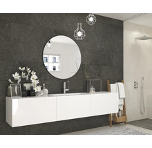 Modernes Badezimmer mit dunklen Wandfliesen in Steinoptik, weißem Hängeschrank, rundem Spiegel und begehbarer Dusche.