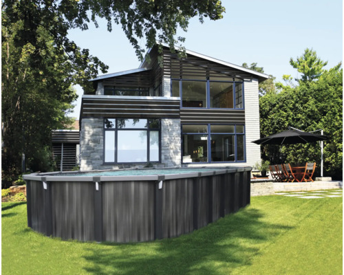 Ovales Aufstellbecken in Holzoptik im Garten vor einem modernen Haus mit Terrasse und Sitzgruppe.