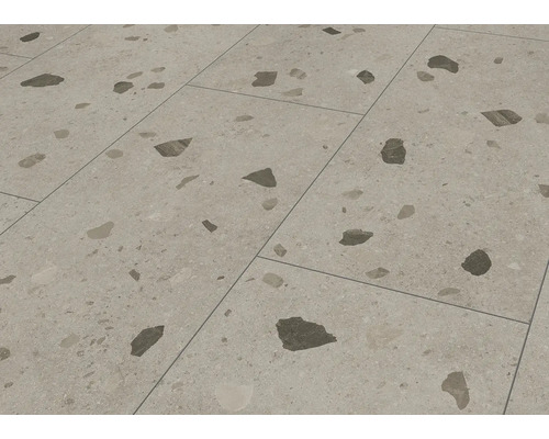 Bodenfliese aus Feinsteinzeug in Terrazzo-Optik mit markanten dunklen Einschlüssen.