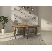 Modernes Esszimmer mit großformatigen Wand- und Bodenfliesen in Terrazzo-Optik, hellem Holztisch, Stühlen und einer Zimmerpflanze.