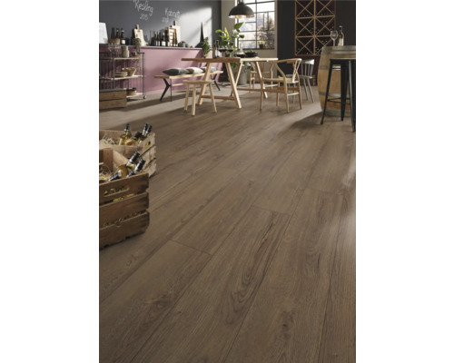 Rustikaler Laminatboden in Eichenoptik in einem hellen, geräumigen Raum mit Holztisch, Sesseln und Weinkisten im Landhausstil.