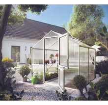 Gewächshaus mit Aluminiumrahmen und Hohlkammerplatten im Garten mit Topfpflanzen und einer Gießkanne.
