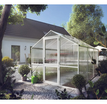Modernes Gewächshaus mit Metallrahmen und transparenten Platten in einem hellen, organisierten Garten neben einem Wohnhaus.