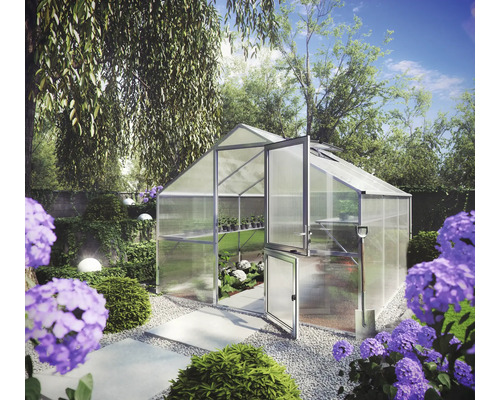 Gewächshaus aus Aluminium mit Hohlkammerplatten und geteilter Tür, freistehend in einem bepflanzten Garten mit Schaufel und Kiesweg.