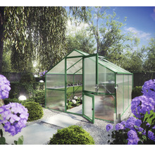 Gewächshaus mit grünem Aluminiumrahmen und Hohlkammerplatten in einem Garten mit Hortensien und Kiesweg.