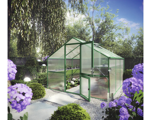 Gewächshaus mit grünem Aluminiumrahmen und Hohlkammerplatten in einem Garten mit Hortensien und Kiesweg.