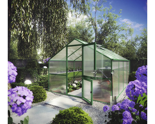 Helles Gewächshaus mit grünem Aluminiumrahmen und Hohlkammerplatten in einem organisierten Garten mit Blumen und Steinplattenweg.
