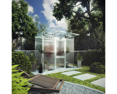 Modernes Gewächshaus aus Aluminium und Glas in einem hellen Garten mit Gabionenwand, Rasen und Steinplatten.