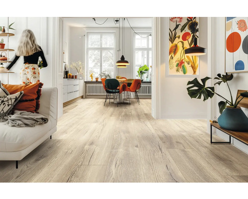 Heller Laminatboden in Eichenoptik in einem modernen, lichtdurchfluteten Wohn- und Essbereich mit weißem Sofa und bunten Stühlen.
