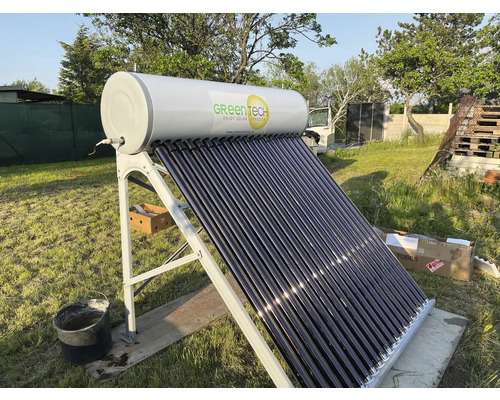 GreenTech Solar-Warmwasserbereiter mit Vakuumröhrenkollektoren, Speicherbehälter und Metallgestell auf einer Wiese.