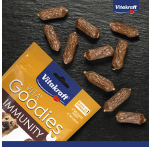 Vitakraft Vita Goodies Immunity Hundesnacks, getreidefrei und ohne Zuckerzusatz, kleine würstchenförmige Belohnungen neben der Verpackung.