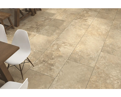 Bodenfliesen in Natursteinoptik verlegt in einem hellen Esszimmer mit Holztisch und modernen Stühlen.