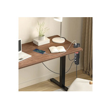 Schreibtisch Steckdosenleiste mit USB Anschlüssen an einem Holztisch in einem hellen organisierten Arbeitszimmer mit Laptop und Lampe.