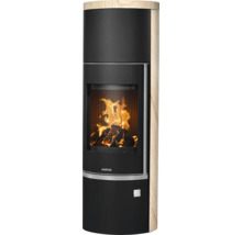 Zylindrischer Kaminofen von Justus mit Sandsteinverkleidung und brennendem Holzfeuer hinter der Glasscheibe.