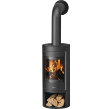 Justus Kaminofen in Schwarz mit großem Sichtfenster, brennendem Holzfeuer, Abgasrohr oben und integriertem Holzfach mit Holzscheiten.