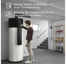 Ein Mann bedient eine Stiebel Eltron Warmwasser-Wärmepumpe im hellen Keller, die unabhängig von Öl und Gas mit Umgebungsluft Wasser erwärmt.