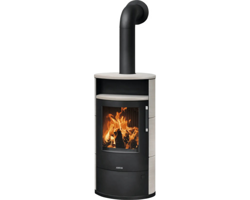 Justus Kaminofen mit Steinverkleidung, Sichtscheibe mit brennendem Holzfeuer und schwarzem Ofenrohr.