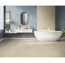 Modernes Badezimmer mit freistehender Badewanne, weißem Waschtisch, ovalem Spiegel und beigefarbenen Bodenfliesen.