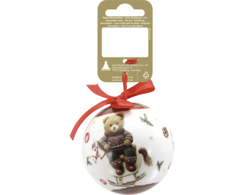 Weihnachtskugel mit Motiv eines Teddybären auf einem Schaukelpferd, rote Schleife und Pappkarte.
