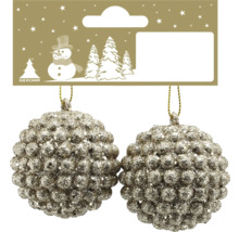 Zwei glitzernde Weihnachtskugeln mit strukturierter Oberfläche und Geroma Logo auf der Verpackung.