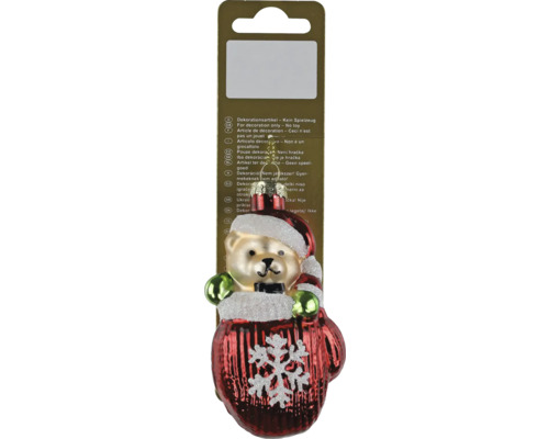 Christbaumschmuck aus Glas, Teddybär mit Weihnachtsmütze in einem roten Fäustling mit weißer Schneeflocke.