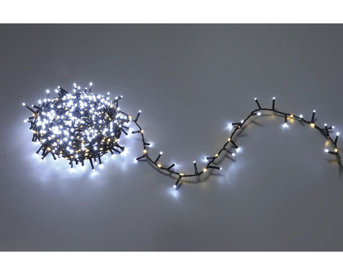 LED-Lichterkette mit kleinen weißen Lämpchen auf dunklem Kabel, teilweise aufgewickelt und teilweise ausgelegt.