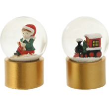 Zwei kleine Schneekugeln auf zylindrischen goldenen Sockeln, eine mit einem sitzenden Elf und eine mit einer roten Spielzeugeisenbahn.