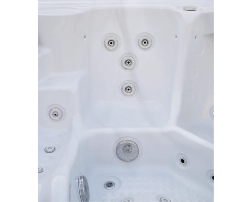 Innenansicht eines Whirlpools mit verschiedenen Massagedüsen und einer Ansaugöffnung am Boden.