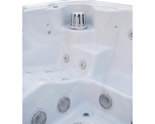 Innenansicht eines weißen Whirlpools mit verschiedenen Massagedüsen, Filtergehäuse und ergonomischen Sitzflächen.