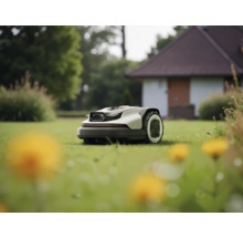 Moderner Mähroboter mäht einen gepflegten Rasen in einem Garten vor einem Haus.