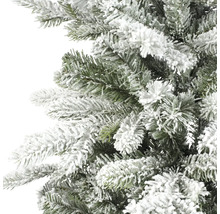 Künstliche grüne Weihnachtsbaumzweige mit weißem Kunstschnee in Nahaufnahme.