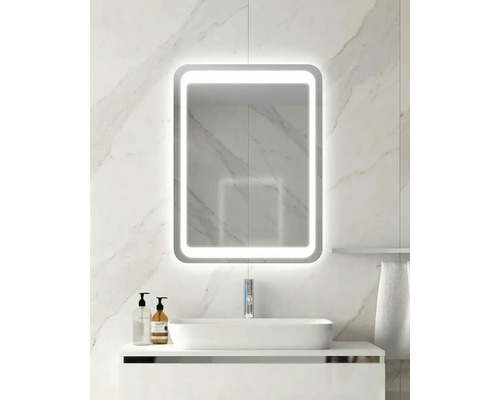 Moderner Badezimmerspiegel mit LED-Beleuchtung, rechteckig mit abgerundeten Ecken, auf einer Wand aus hellem Marmor über einem Waschbecken.