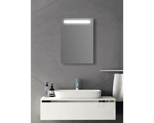 Rechteckiger Badezimmerspiegel mit integrierter LED-Beleuchtung über einem weißen Waschbecken und Unterschrank an einer grauen Wand.