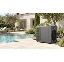 Graue Steinbach Pool-Wärmepumpe neben einem hellen Außenpool in einem mediterranen Garten mit Steinplatten und Liegestühlen.