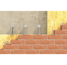 Querschnitt einer Wandkonstruktion mit Daemmung aus Mineralwolle, Wandhaltern aus Metall und einer Ziegelfassade auf Beton.