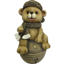 Brauner Bär aus Magnesia auf einer Kugel mit Sternen, mit Mütze und Schal.