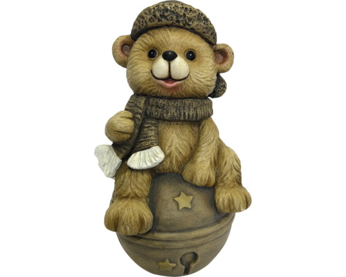 Brauner Bär aus Magnesia auf einer Kugel mit Sternen, mit Mütze und Schal.