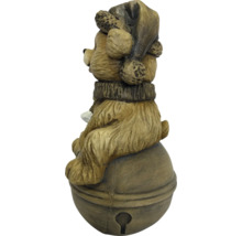 Weihnachtsfigur Bär mit Mütze und Schal sitzend auf einer Glocke