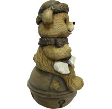 Dekofigur brauner Bär mit Wintermütze und Schal sitzend auf einer Glocke mit Sternmotiv.