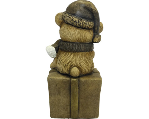 Weihnachtsfigur Bär in Rückansicht mit Weihnachtsmütze und Schal, sitzend auf einem Geschenkpaket.