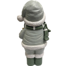 Rückansicht einer Weihnachtsfigur aus Polyresin mit Winterbekleidung, Mütze mit Bommel, Schal und Stiefeln.