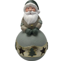 Weihnachtsfigur Weihnachtsmann auf einer Kugel sitzend, mit Bart und Zipfelmütze, Goldband mit Sternenausstanzungen und Tannenbaum.