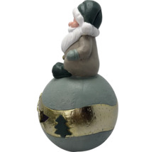 Weihnachtsmann-Figur auf einer Kugel mit goldenem Band und Tannenbaum-Ausschnitt, aus Keramik.