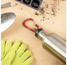 Nite Ize Karabiner SlideLock an einer Edelstahl Trinkflasche neben Gartenhandschuhen und einer Pflanzschaufel.