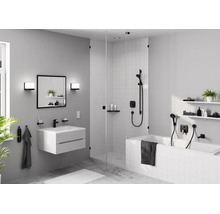 Modernes Badezimmer mit weißem Waschtisch, schwarzer Armatur, Spiegelschrank, begehbarer Glasdusche und Badewanne mit schwarzen Armaturen.